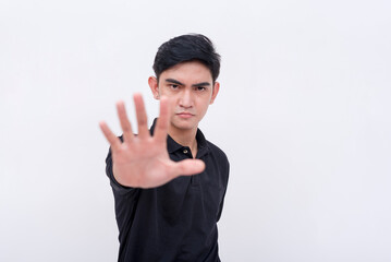 A stern young man commands to stop. Rejecting an offer or deal. Mad or irked from a proposal. Isolated on a white background.