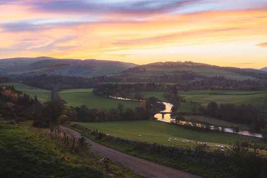 Beautiful landcape view at sunset in Autumn of rolling hills and rural countryside with Old Manor Bridge over the River Tweed near Peebles in the Scottish Borders of Scotland, UK.