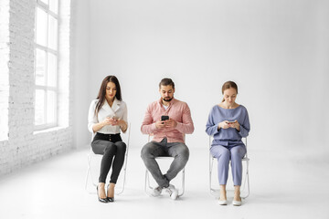 group of people sitting on chairs and using digital devices, concept, original photoset