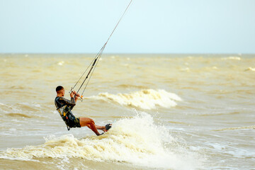 Young Man KiteBoarding on the waves Extreme Sport Kitesurfing