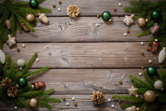golden christmas toys with fir branches on dark wooden background