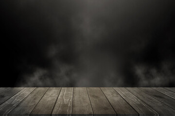 Empty wooden table for product display montages. Black background with space for your text. Smoke and mood photo.