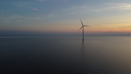 Aerial photo of wind turbines in the sea during sunset