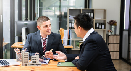 Real estate broker agent presenting and consult to customer to decision making sign insurance form agreement, home model, concerning mortgage loan offer in office..