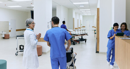 Day hospital. Rear view of clinic corridor during workflow of hospital with doctors, patients and...