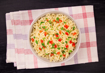 Instant noodles in bowl on black background