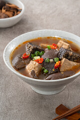 Spicy duck blood jelly soup and stinky tofu with scallion and chili pepper topping.