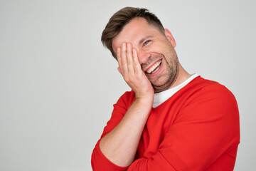 Mature man covering his face and smiling being pleased with compliment