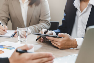 Close up hands of a businessman holding graph paperwork on the meeting conference table.
