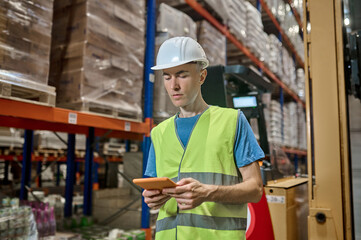 Fototapeta na wymiar Warehouse manager using the gadget in the workplace