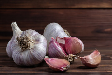 Garlic cloves on wooden table. Fresh peeled garlics and bulbs.