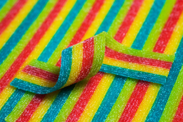 Rainbow sour jelly candies strips in sugar sprinkle.