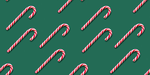 Seamless pattern of Christmas candy cane on a green background. Flat lay. Xmas flyer or greeting...