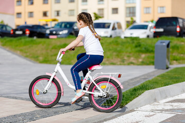 Fototapeta na wymiar Little girl on a bicycle in summer park. cycling outdoors