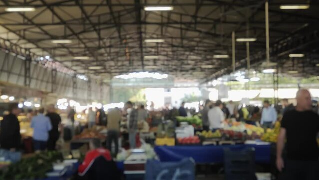 The general outline of the atmosphere of a farmer's market with a large number of people is out of focus. Beautiful background with a farmer's market frame without image focus. High quality 4k footage