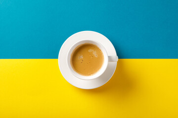 Black coffee in a cup on Ukraine flag blue and yellow background