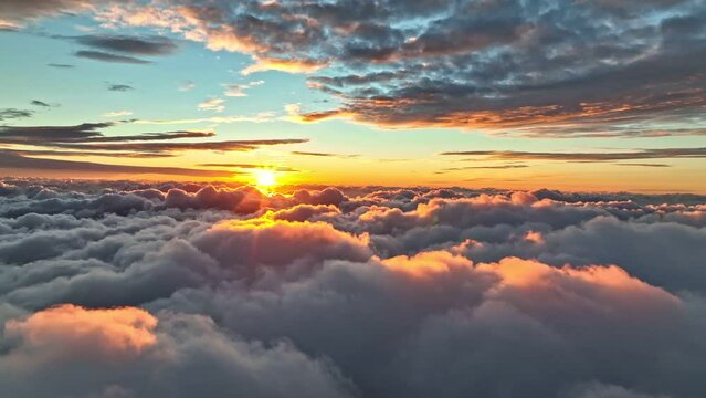 Magnificent sunrise on dense clouds. Aerial view of sun rises from behind the clouds starting a new day. Rising sun illuminates clouds in bright pink color. Great sunrise at Madeira island