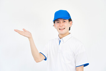 左を手のひらで指す引越し業者の男性　白背景