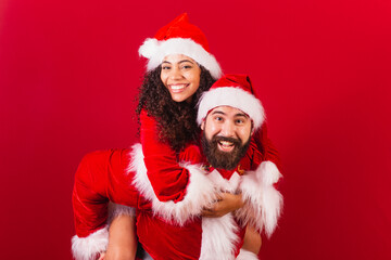 brazilian couple, dressed for christmas, santa claus, mummy claus. playing together, hugging....