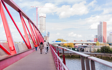 public single span pedestrians foot bridge over river lea links east london city Island apartment housing and offices to canning town dlr station, october 22, 2022 in london, united kingdom - obrazy, fototapety, plakaty