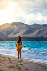Fototapeten A beautiful girl walks along a paradise beach on the Hawaiian island of oahu overlooking the mighty green mountains  holiday in hawaii © Jakub
