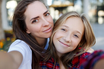 Selfie together. Happy smiling mother and her teenage daughter taking a selfie