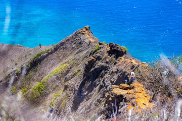 girl in a hat enjoys the oahu panorama from the top of the famous koko crater railway trailhead,...
