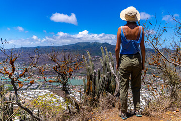 girl in a hat enjoys the oahu panorama from the top of the famous koko crater railway trailhead, oahu, hawaii, hiking in hawaii, holiday in hawaii