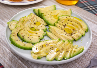 ripe avocado pulp cut into pieces sprinkled with lemon juice on a plate