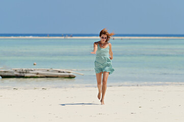 Fototapeta na wymiar Young pretty woman on the tropical sandy beach with turquoise water sea background, Zanzibar 