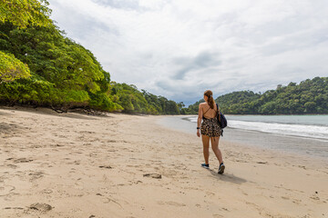Girl walking on a beach on the coast of the Pacific Ocean in Costa Rica. Manuel Antonio Park