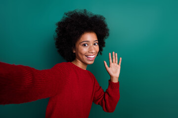 Photo portrait of cute schoolgirl take selfie record video wave hand wear trendy red knitted clothes isolated on green color background