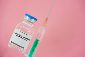 Follicle-stimulating hormone (FSH). Test tube with artificial hormone on pink background...