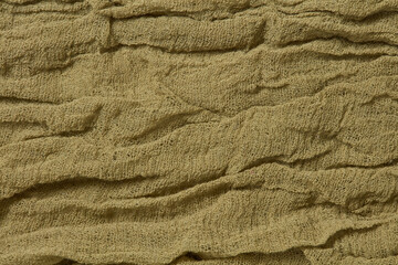 Folded cotton gauze fabric background. Crinkle green, khaki gauze fabric. Dyed gauze fabric