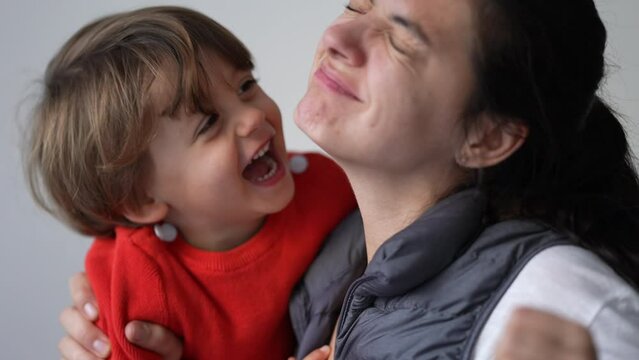 Woman hurting back while holding child. Mother hurts body muscle. Person suffering from painful injury. Spine back pain while playing with son