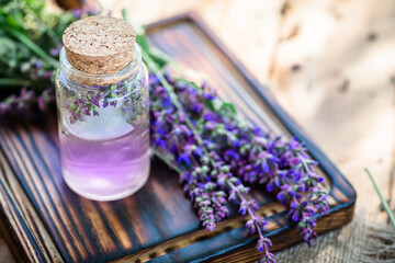 Obraz na płótnie Canvas sage essential oil with fresh Salvia pratensis , meadow clary or meadow sage purple. In the yard of a village house near a herbalist. Preparation essential oils from fresh flowers