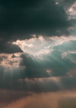 The sun's rays passing through the clouds and shining form an interesting light pattern against the sky. Space for text, Selective focus. © num
