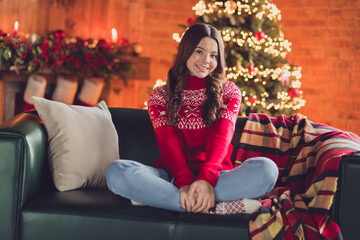 Obraz na płótnie Canvas Portrait of optimistic satisfied friendly pleasant girl with wavy hairdo dressed red ornament sweater sit on cozy couch in house indoors