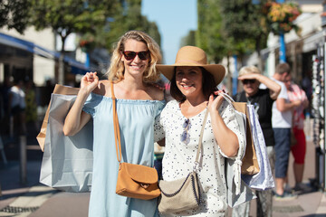 happy young women shopping outdoors