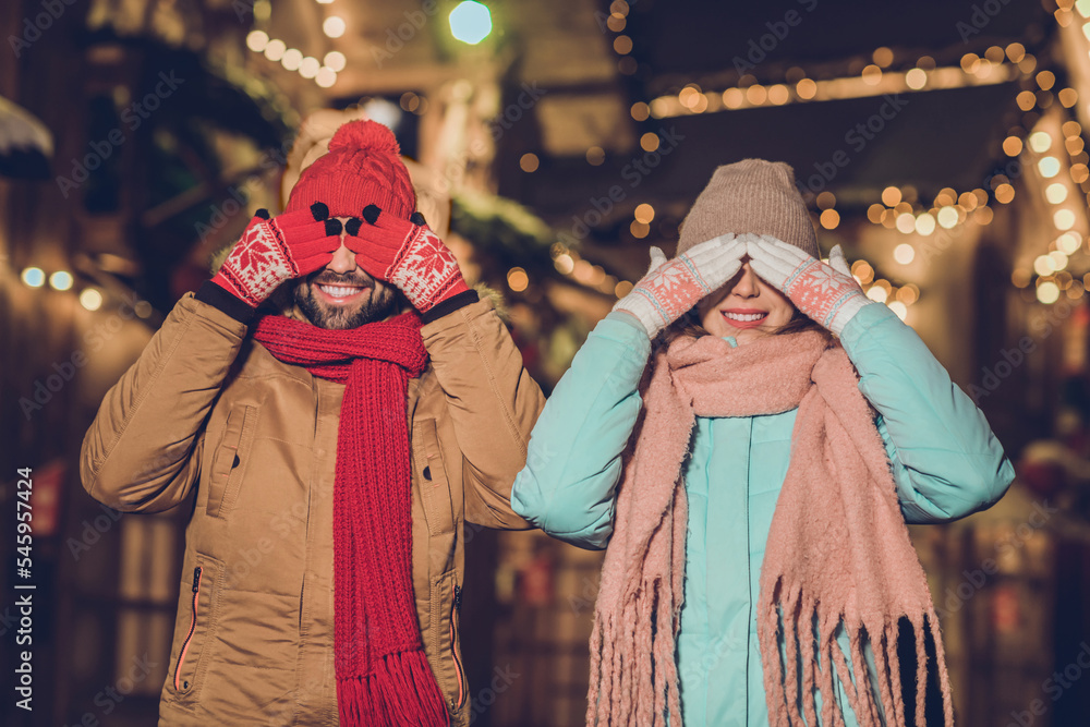 Poster Photo of two positive carefree people arms covering eyes toothy smile evening lights outside