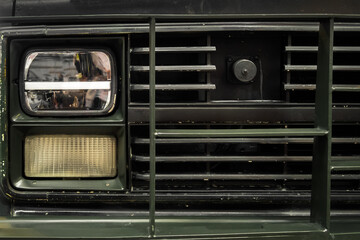 Fototapeta na wymiar Photo of an old green car. Headlight. Retro automobile