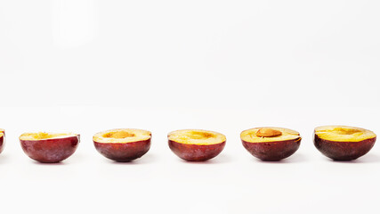 Plum halves with and without pit on white