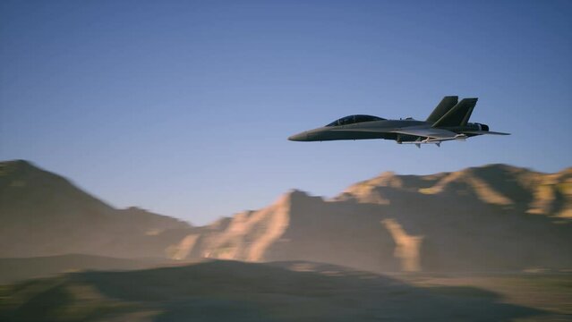 A military fighter jet flying at high speed and low altitude over the mountains.