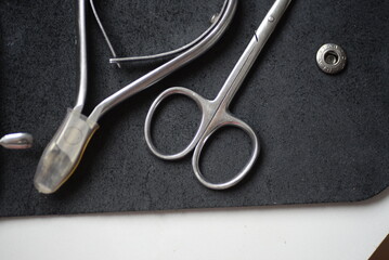 iron tools for a home beauty salon on the background of a leather black tool case, pedicure...
