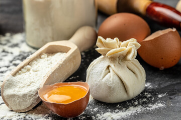 Raw Khinkali with meat, on a wooden board with flour, semi-finished products dumplings cooking khinkali. Georgian dumplings