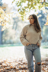 Young woman walking in autumn park