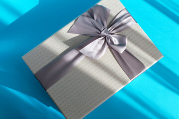 Gray gift box with a bow on a light blue background