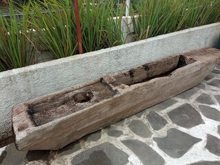 The old broken wooden mortar used for exterior ornament in the cafe