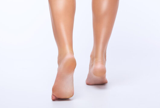 Beautiful slender legs of a woman on a white background. Feet close up. Podiatrist appointment.