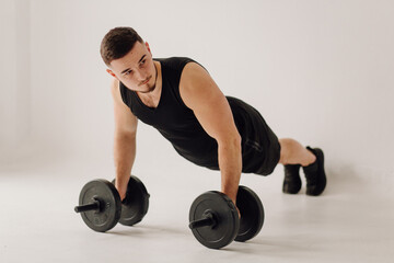 Athletic young man doing workouts at home, man doing training, warm up before weight exercise.